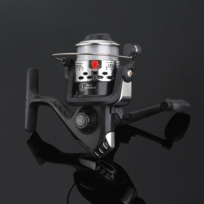 Fishing reel with metallic finish on a reflective black surface